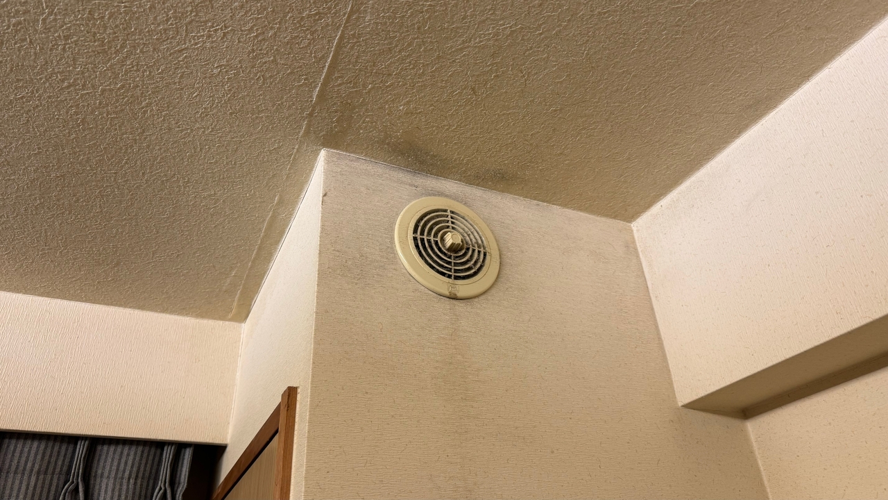 Plafond sale avec un ventilateur d'extraction visible.