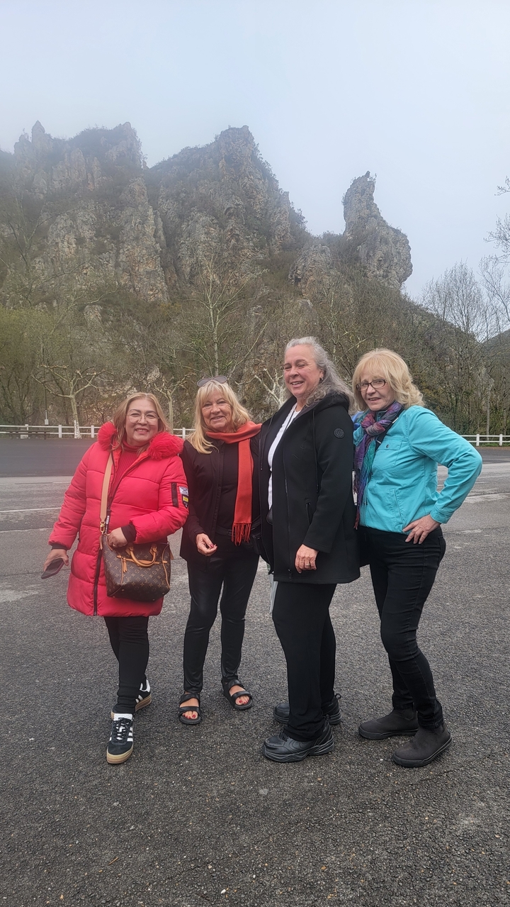 Quatre femmes posant en extérieur avec un arrière-plan d'arbres.