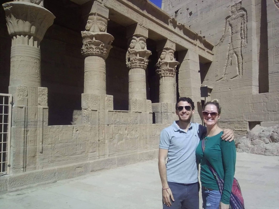 Un couple posant devant des colonnes anciennes avec des sculptures.