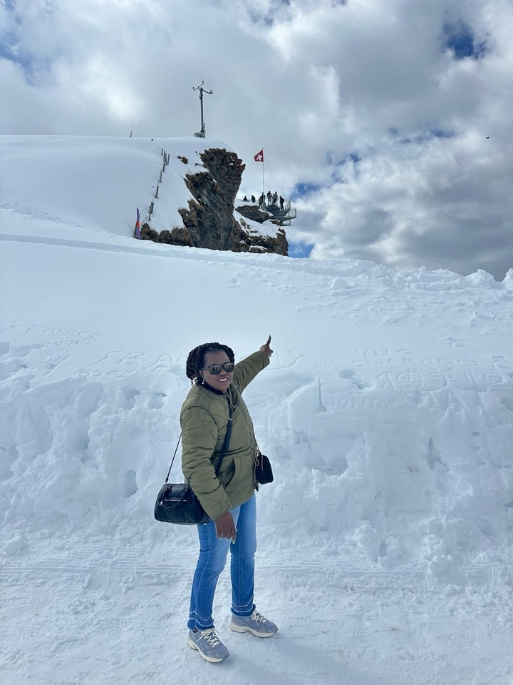 Personne qui pose dans la neige avec des messages sculptés dans la neige.