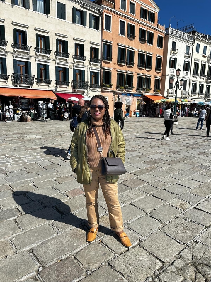 Personne debout sur une place publique avec des bâtiments historiques.