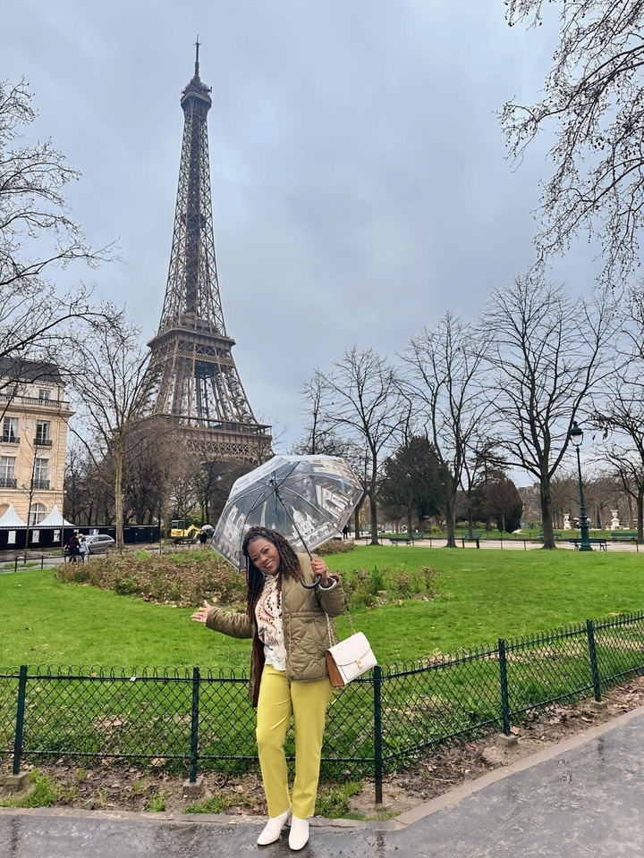 Personne tenant un parapluie devant la tour Eiffel.