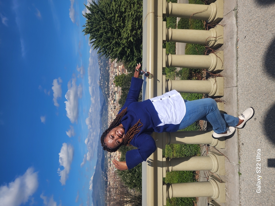 Personne posant avec une vue de la ville en arrière-plan.