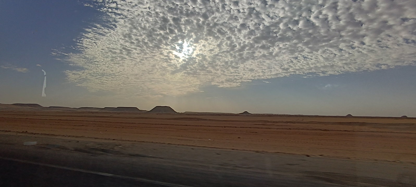 Paysage désertique avec un ciel dramatique et un horizon.