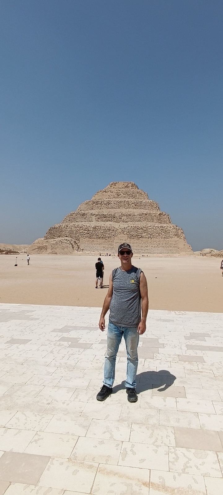 Personne debout devant une pyramide à degrés avec d'autres qui explorent.
