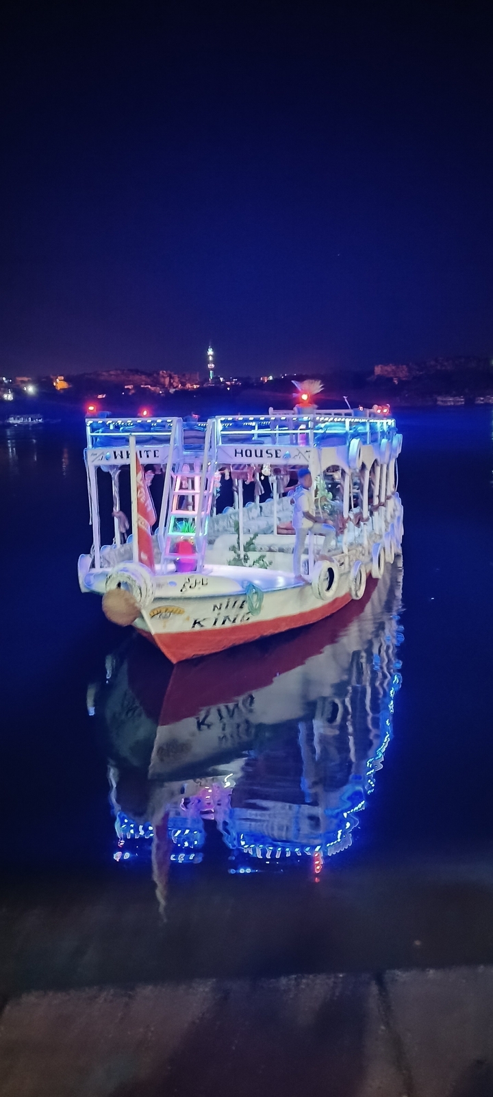 Bateau illuminé sur l'eau la nuit.