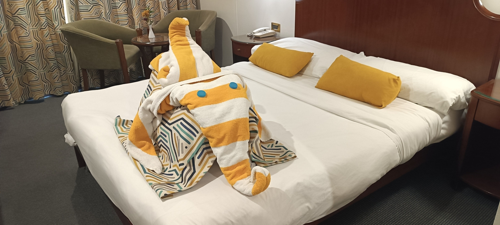 Chambre d'hôtel avec des serviettes décorées sur le lit.