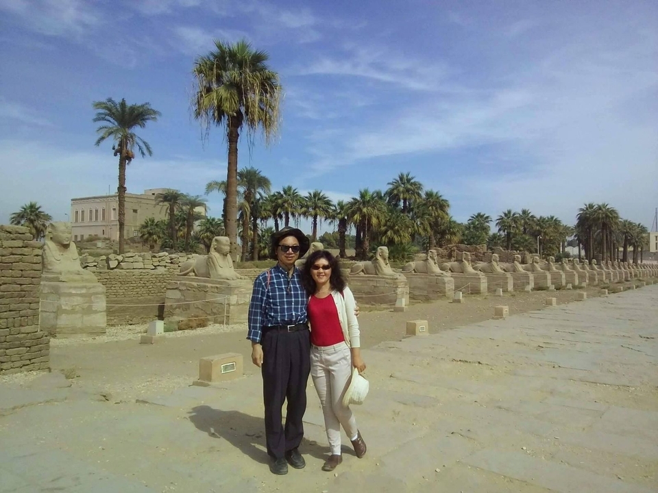 Couple posant devant une allée de sphinx.