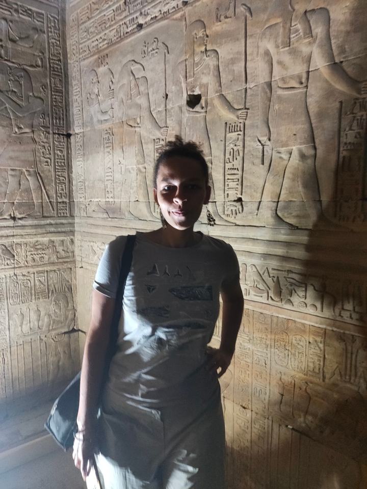 Personne debout contre un mur ancien avec des hiéroglyphes.