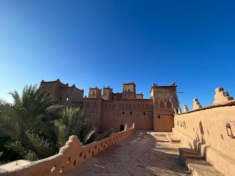 Une kasbah marocaine traditionnelle aux détails complexes sous un ciel bleu.
