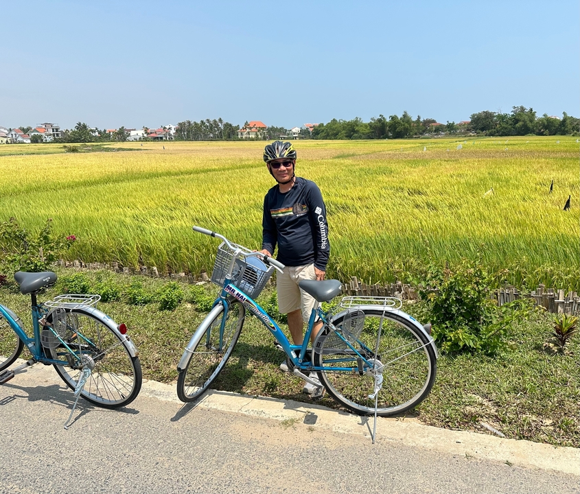 Personne avec un vélo dans une rizière.
