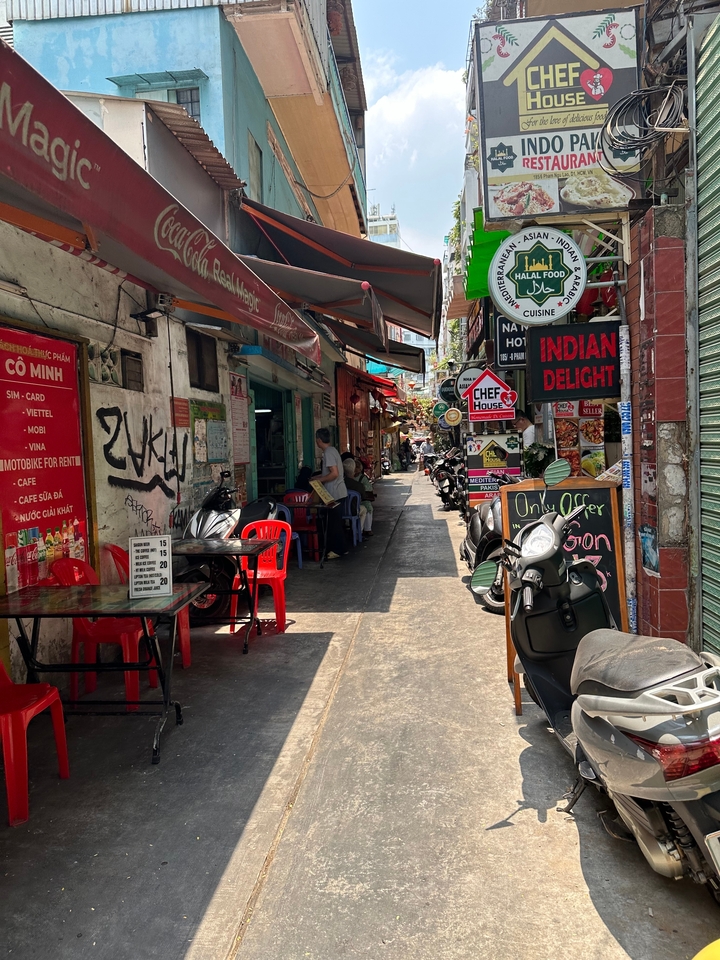 Ruelle étroite dans une ville avec des stands de nourriture et des boutiques.