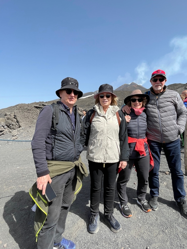 Groupe de personnes posant devant un paysage montagneux.