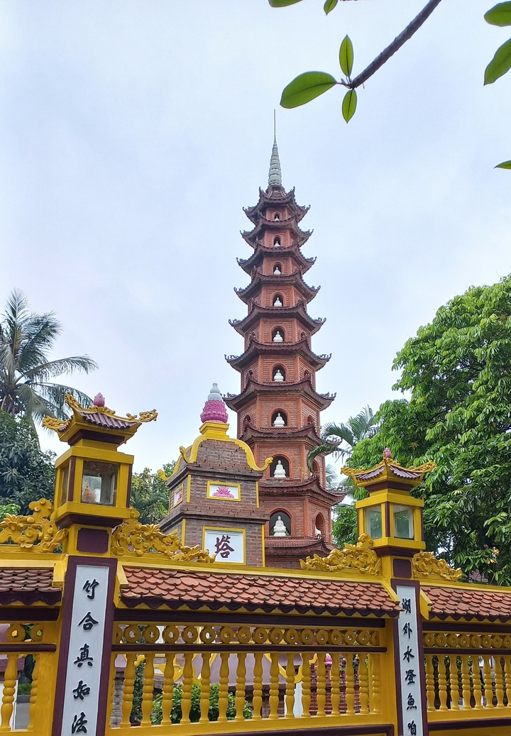 Pagode entourée d'une végétation luxuriante et d'une structure traditionnelle.