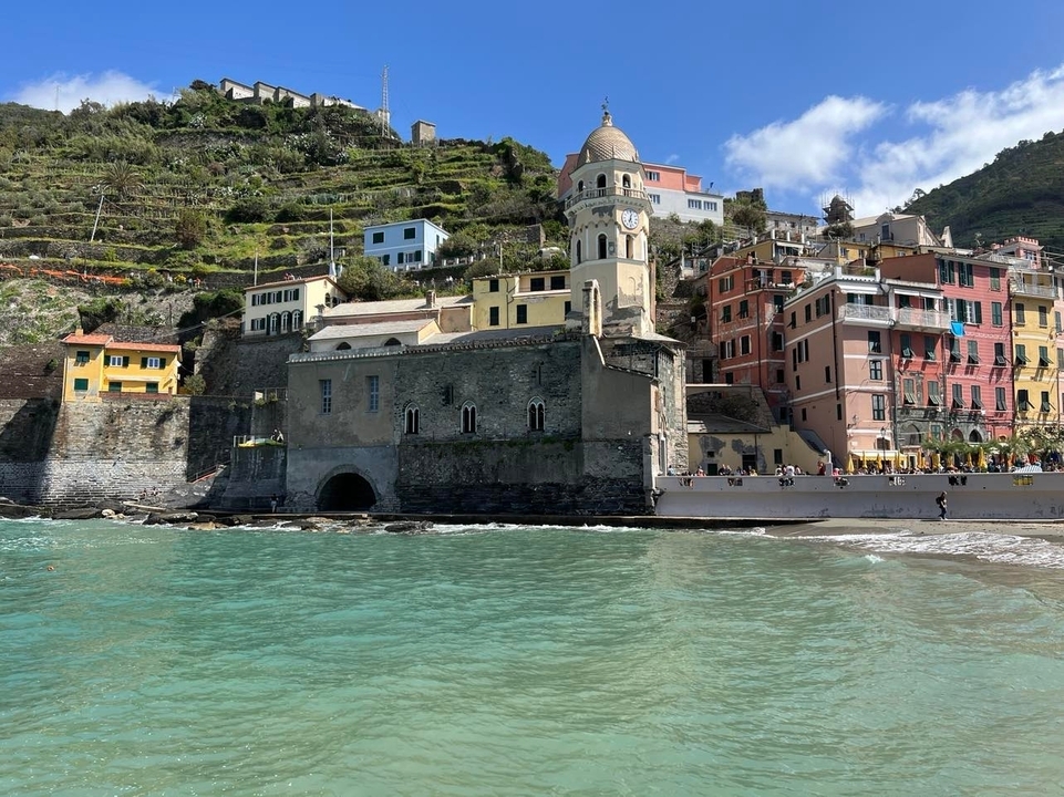 Des bâtiments colorés le long d'un littoral avec des collines en arrière-plan.