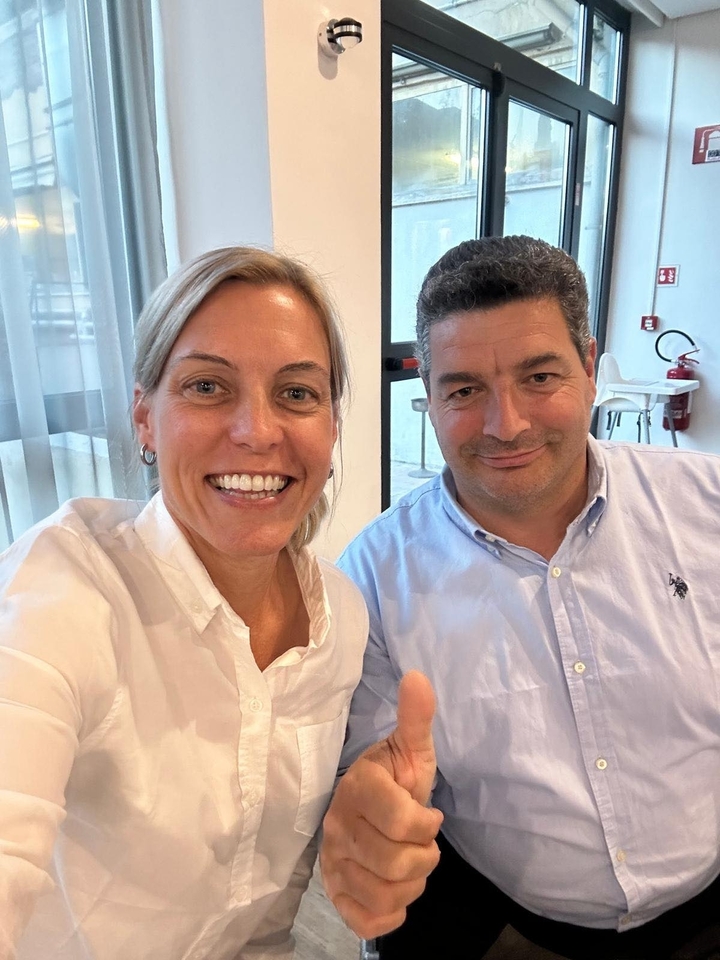 Un gros plan de deux personnes souriantes à l'intérieur.