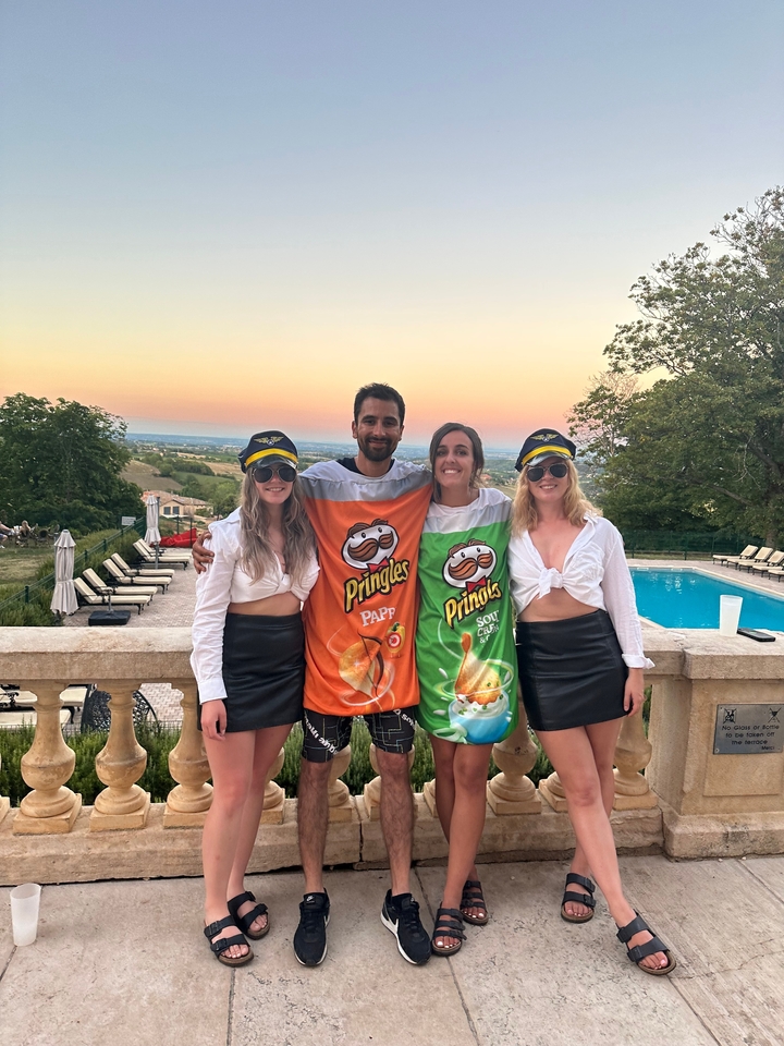 Groupe de personnes posant en costumes près d'une piscine.
