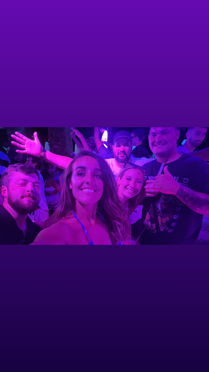 Groupe de personnes profitant d'une vie nocturne animée avec un éclairage coloré.