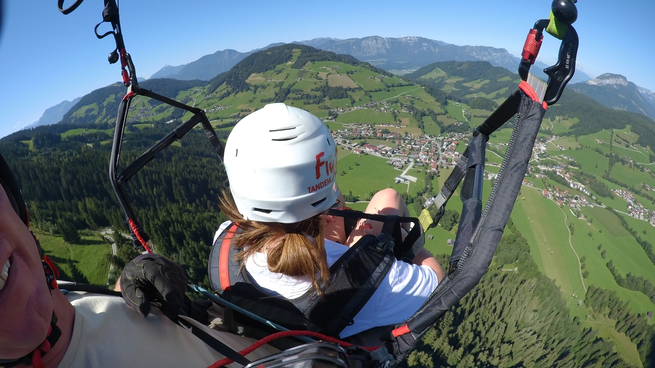 Personne faisant du parapente au-dessus d'un paysage montagneux pittoresque.