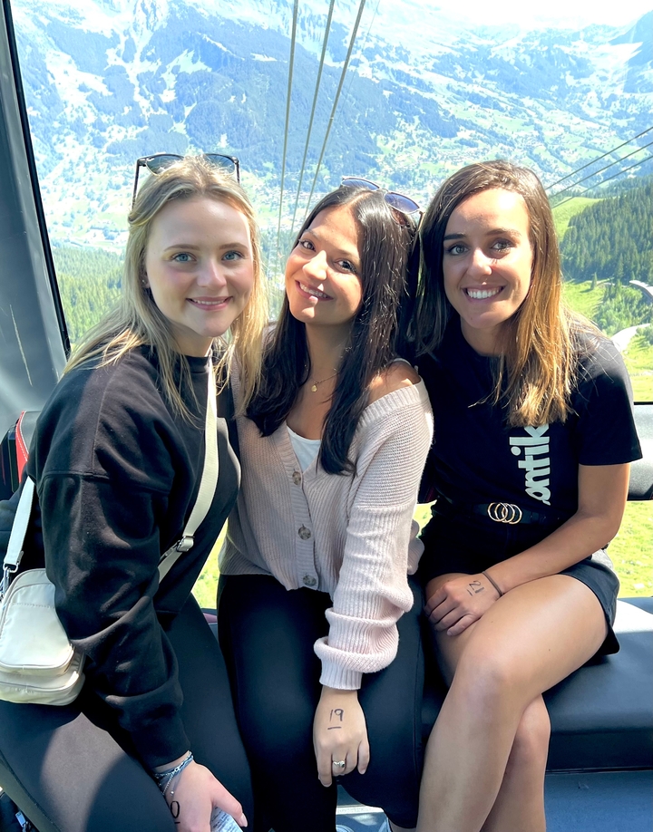 Trois amis dans un téléphérique profitant de la vue.