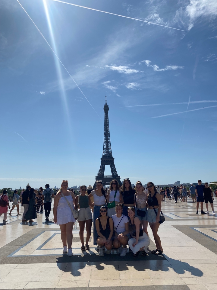 Groupe de personnes devant la tour Eiffel pendant la journée.