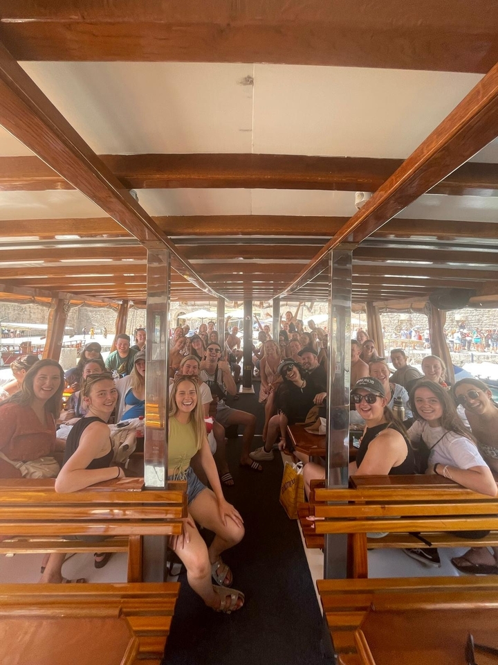Grand groupe posant à l'intérieur d'un bateau en bois.