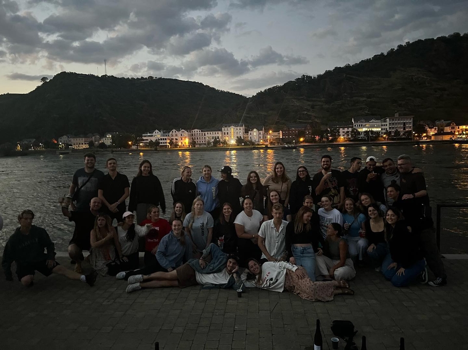 Photo de groupe prise la nuit avec une rivière et les lumières de la colline.