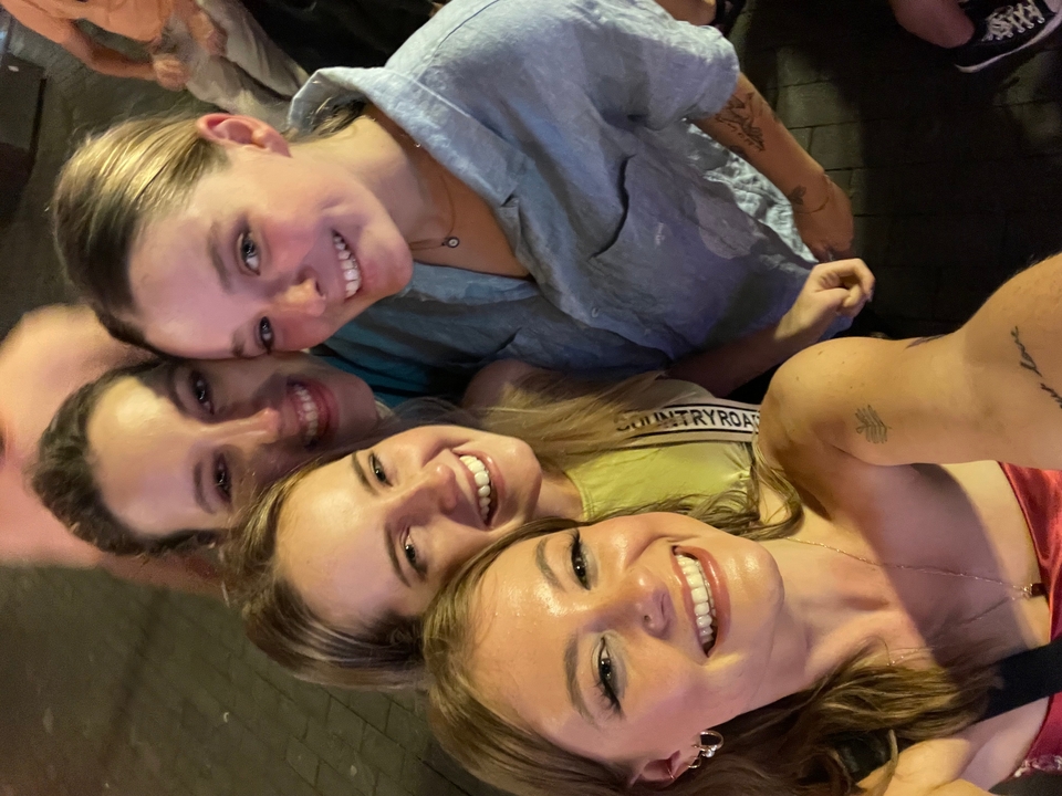 Un groupe de personnes souriantes pour un selfie la nuit.