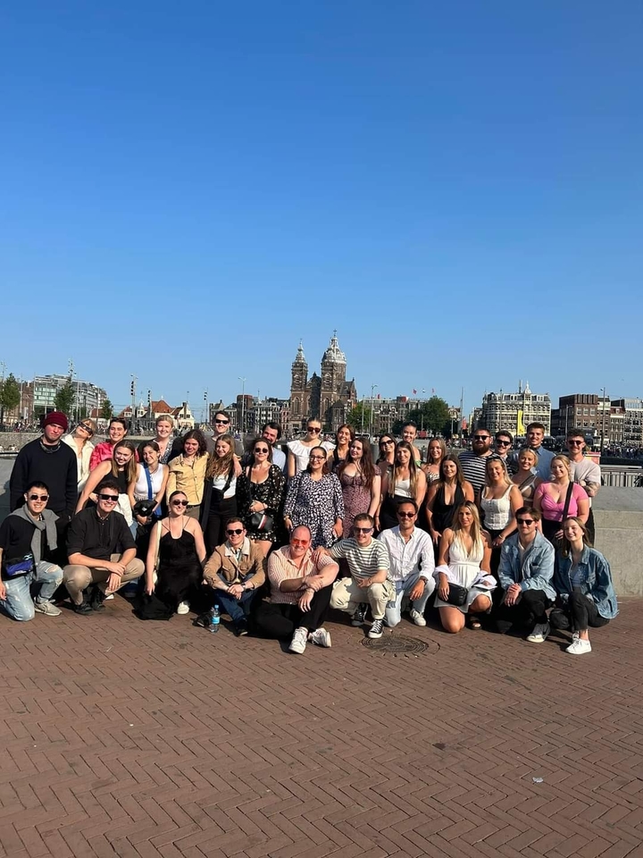 Groupe posant avec un paysage urbain présentant l'horizon d'Amsterdam.