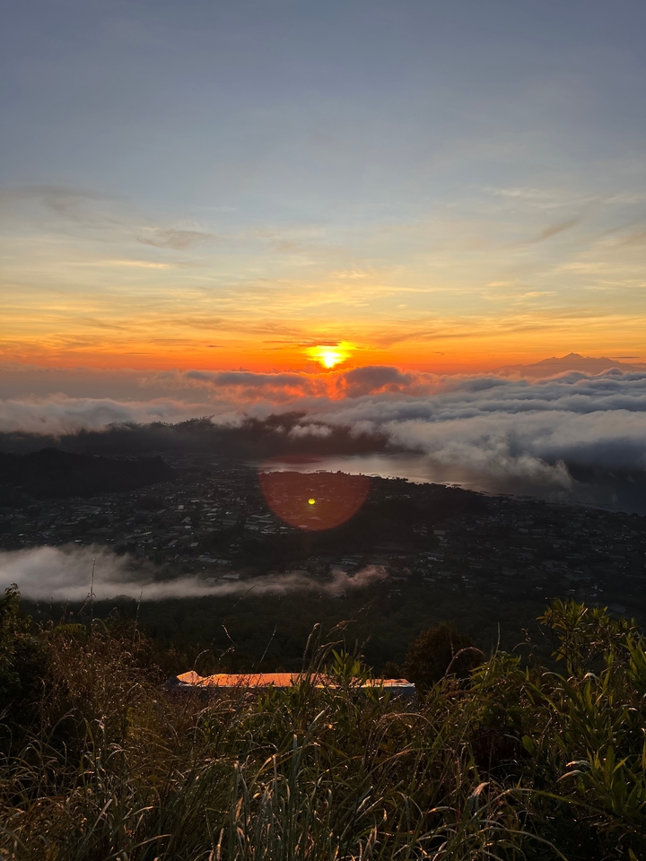Coucher de soleil époustouflant sur un paysage avec des nuages et une ville en contrebas.