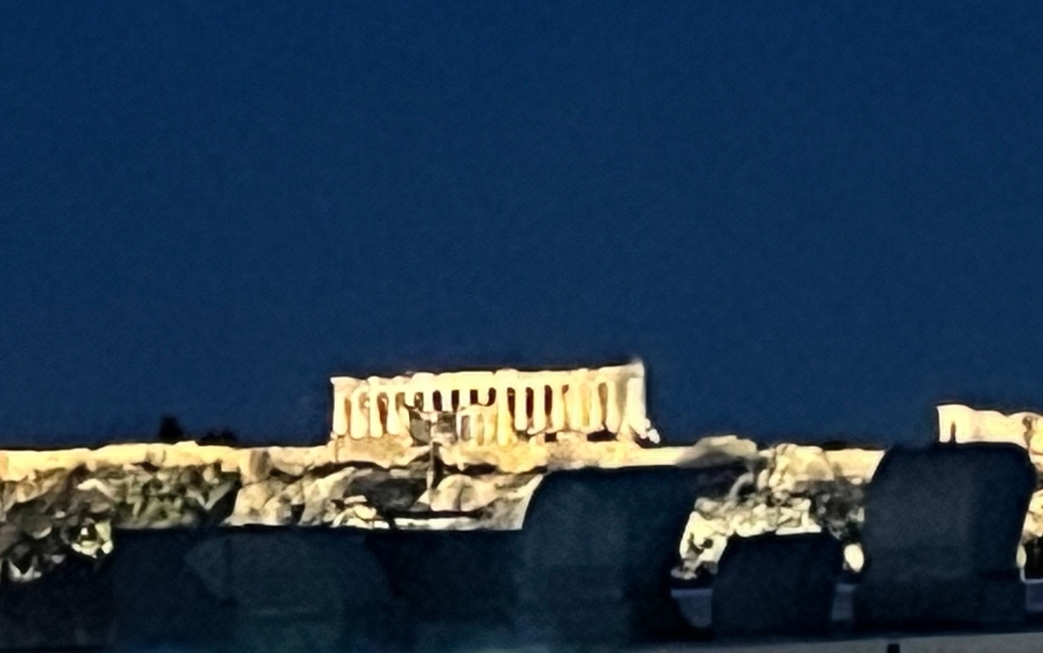 Une vue nocturne du Parthénon, vivement éclairé.