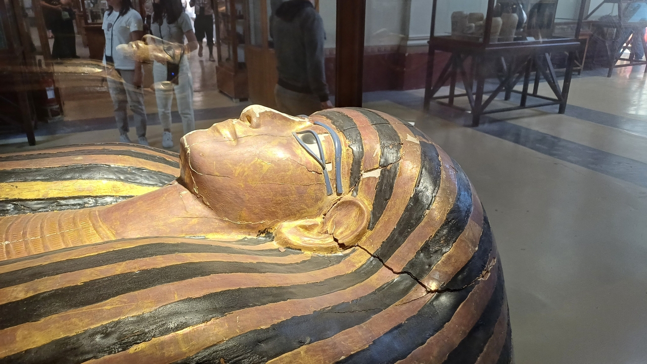 Sarcophage égyptien antique avec des ornements colorés exposé dans un musée.