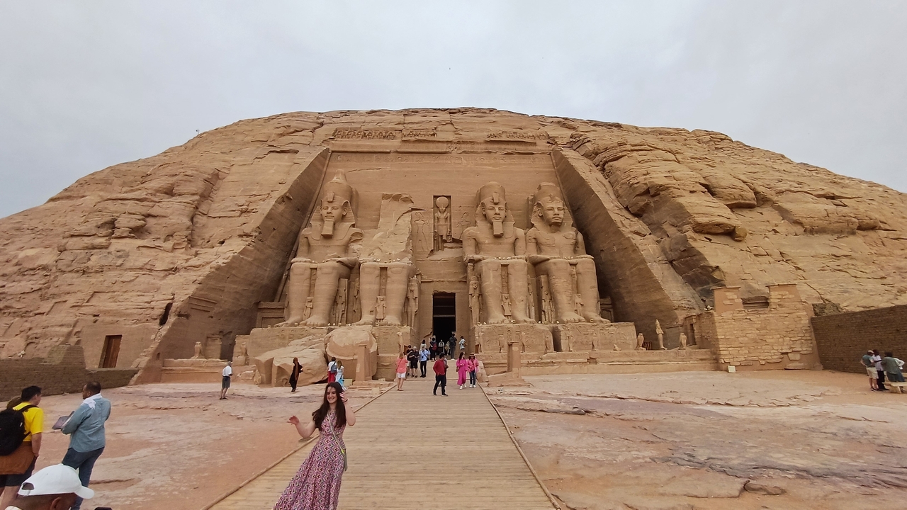 Vue de face des temples d'Abou Simbel avec des touristes en visite.