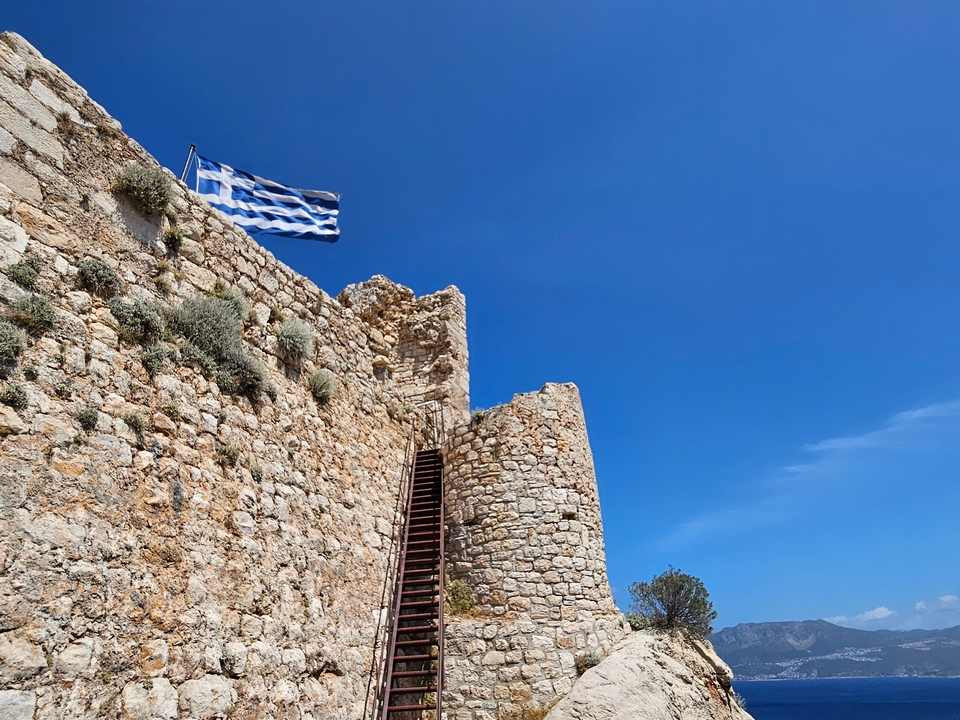 Fort en pierre avec le drapeau grec qui flotte au sommet.