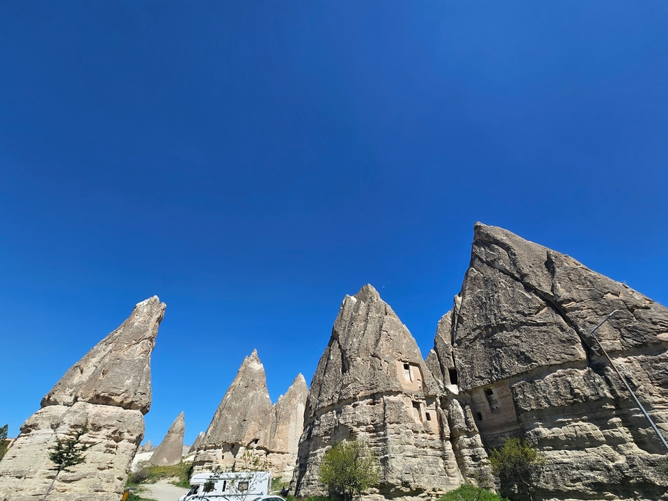 Formations rocheuses en Cappadoce sous un ciel bleu dégagé.