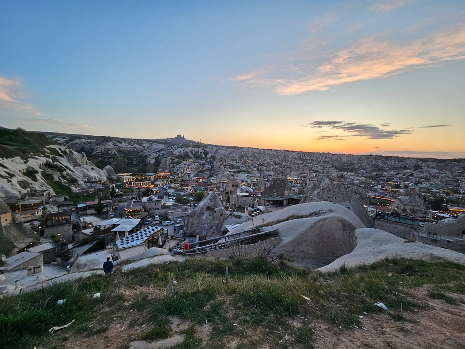 Vue panoramique de la Cappadoce avec formations rocheuses au coucher du soleil.