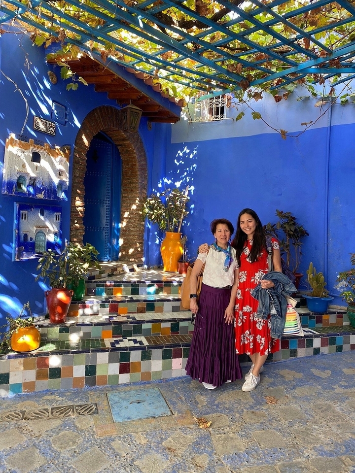 Deux personnes posent dans une cour colorée.