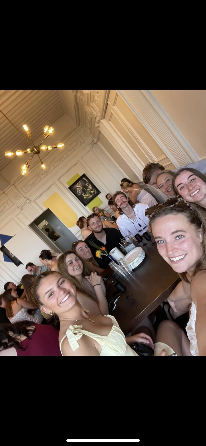 Groupe d'amis dînant dans un cadre intérieur animé.