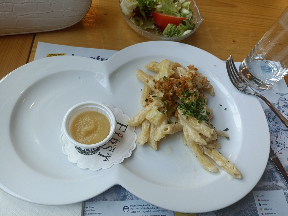 Assiette de pâtes avec sauce et garniture sur une table.