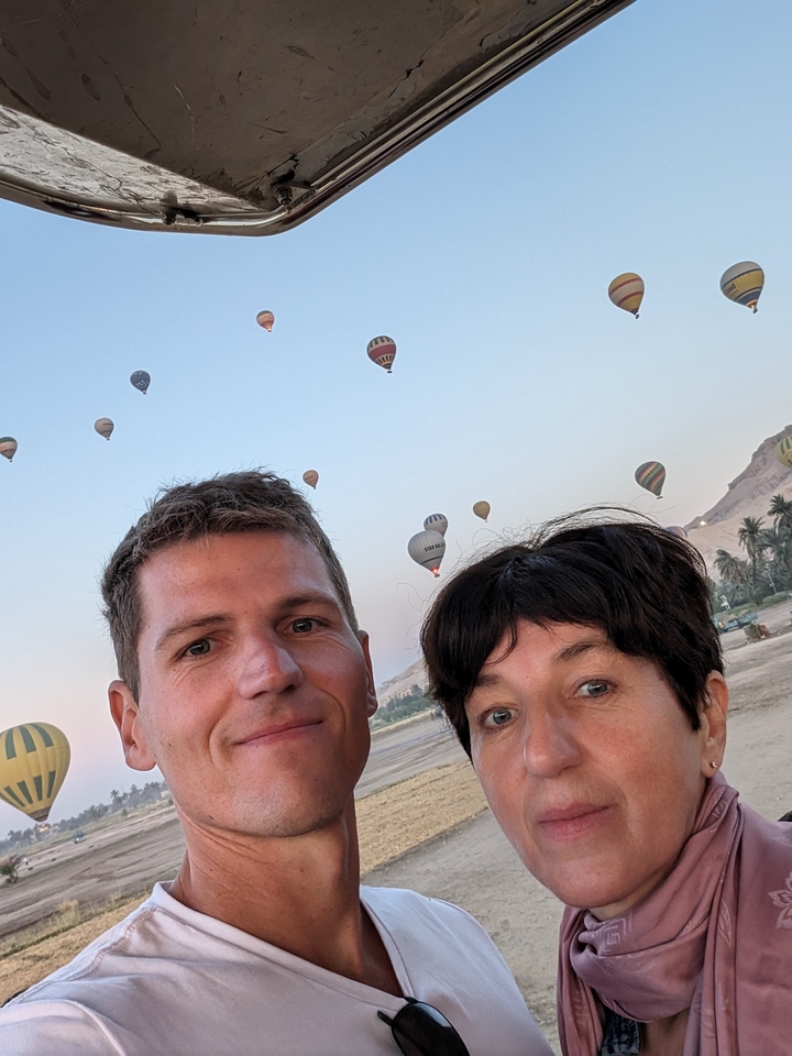 Couple avec des montgolfières dans le ciel.