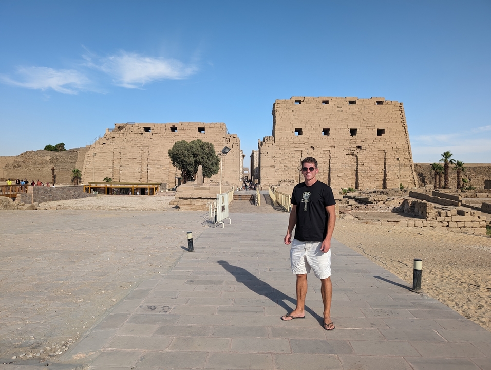 Homme debout devant les ruines du temple de Karnak.
