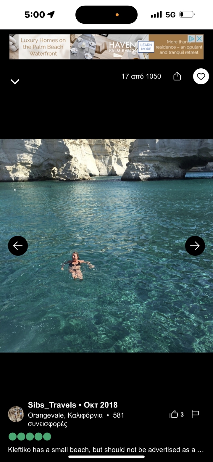 Personne nageant dans une eau bleue claire avec un arrière-plan rocheux.