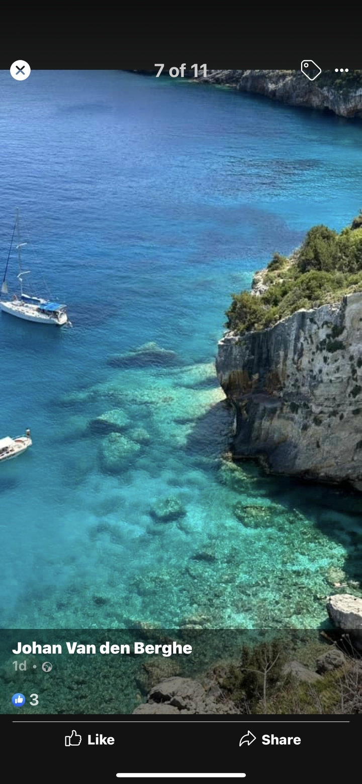 Falaise côtière avec une eau turquoise claire et des rochers visibles en dessous.