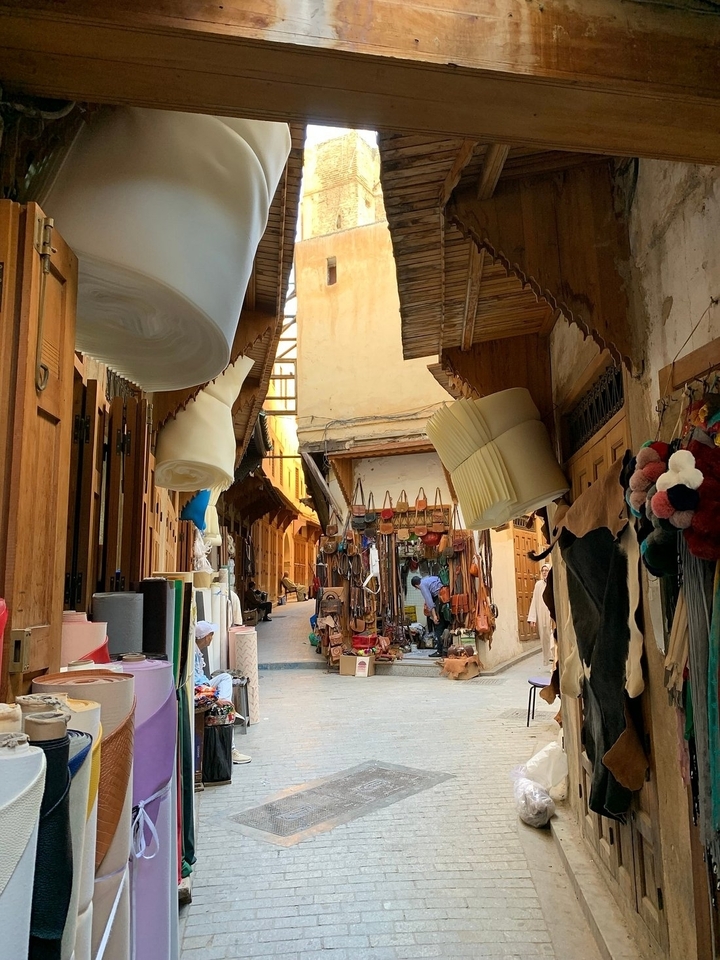 Rue du marché dans une ville marocaine avec diverses marchandises.