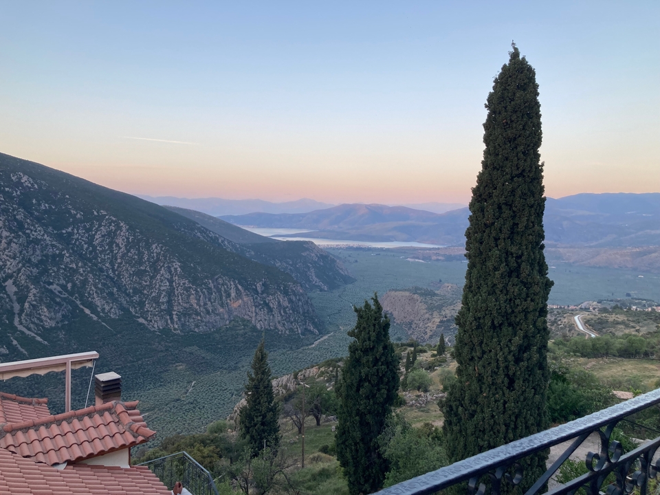 Une vue sereine de vallée avec des montagnes en arrière-plan au coucher du soleil.