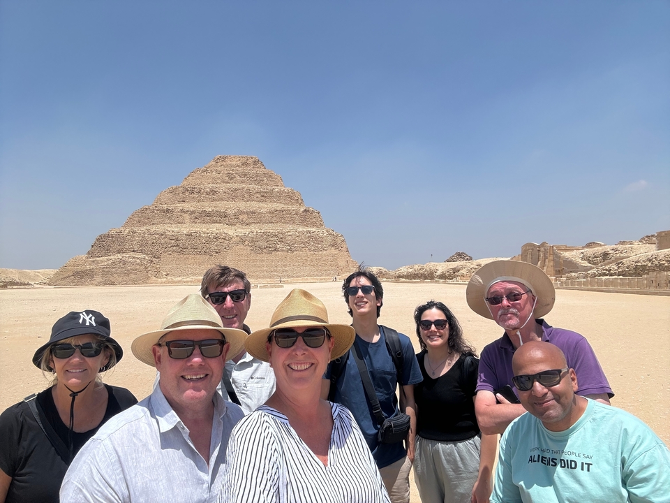Groupe de personnes posant devant une pyramide historique.