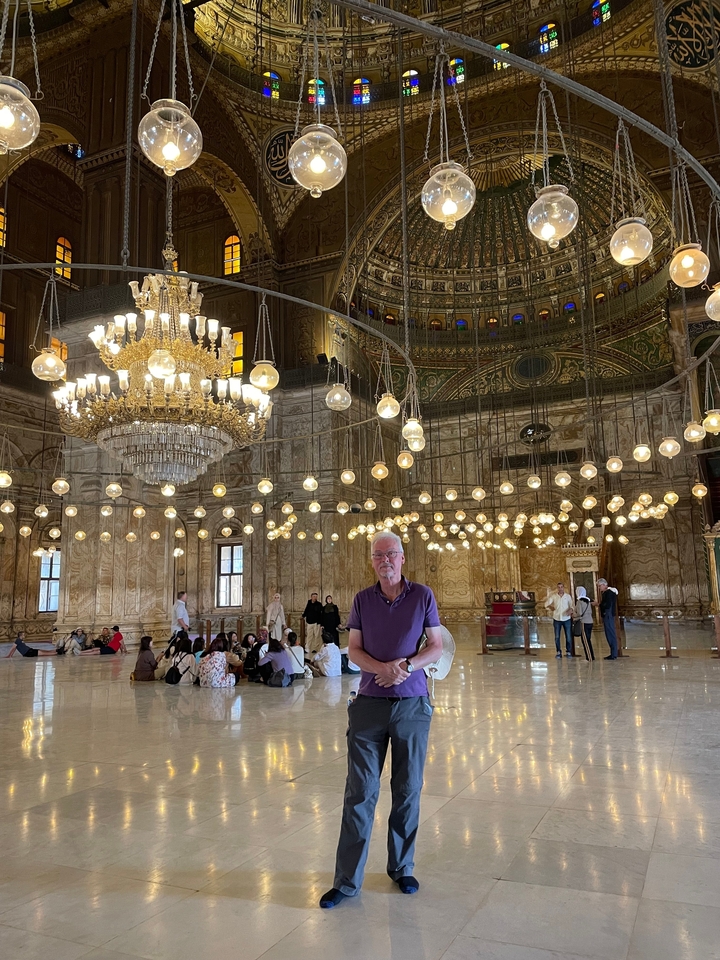 Des personnes à l'intérieur d'un bâtiment historique magnifiquement éclairé.