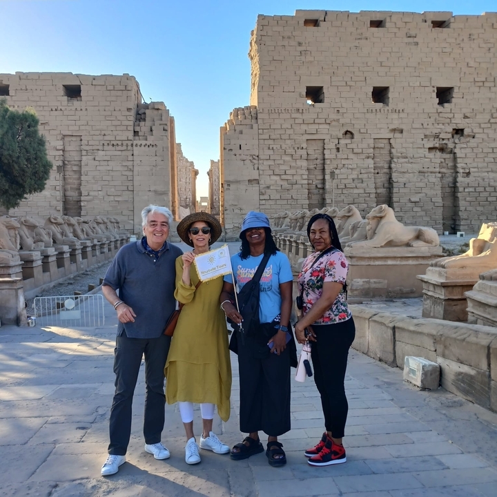 Groupe de touristes devant des ruines de temple ancien.