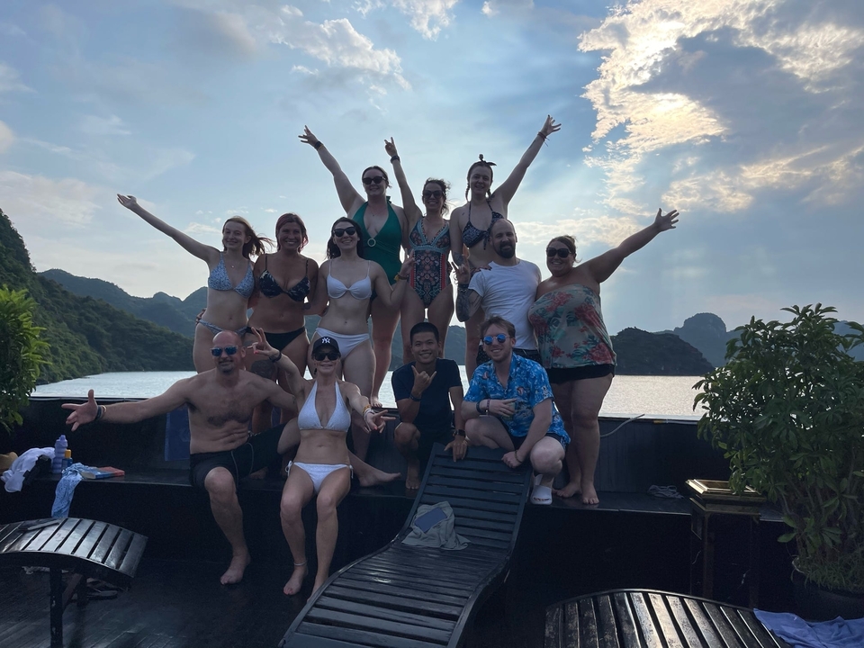 Groupe de personnes en maillots de bain sur un bateau avec un arrière-plan luxuriant.