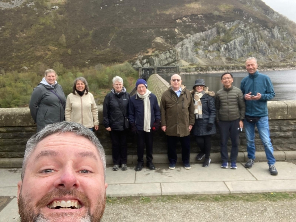 Groupe de personnes posant sur un pont de pierre.
